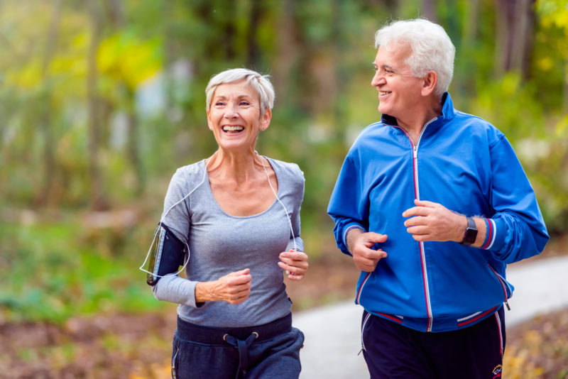 Senior Couple Exercising in Park. Post Menopause Leg Artery Disease is More Common in Women.